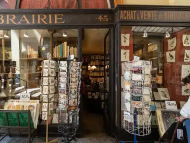 Une femme regarde des cartes postales devant la librairie Jousseaume à Paris.
