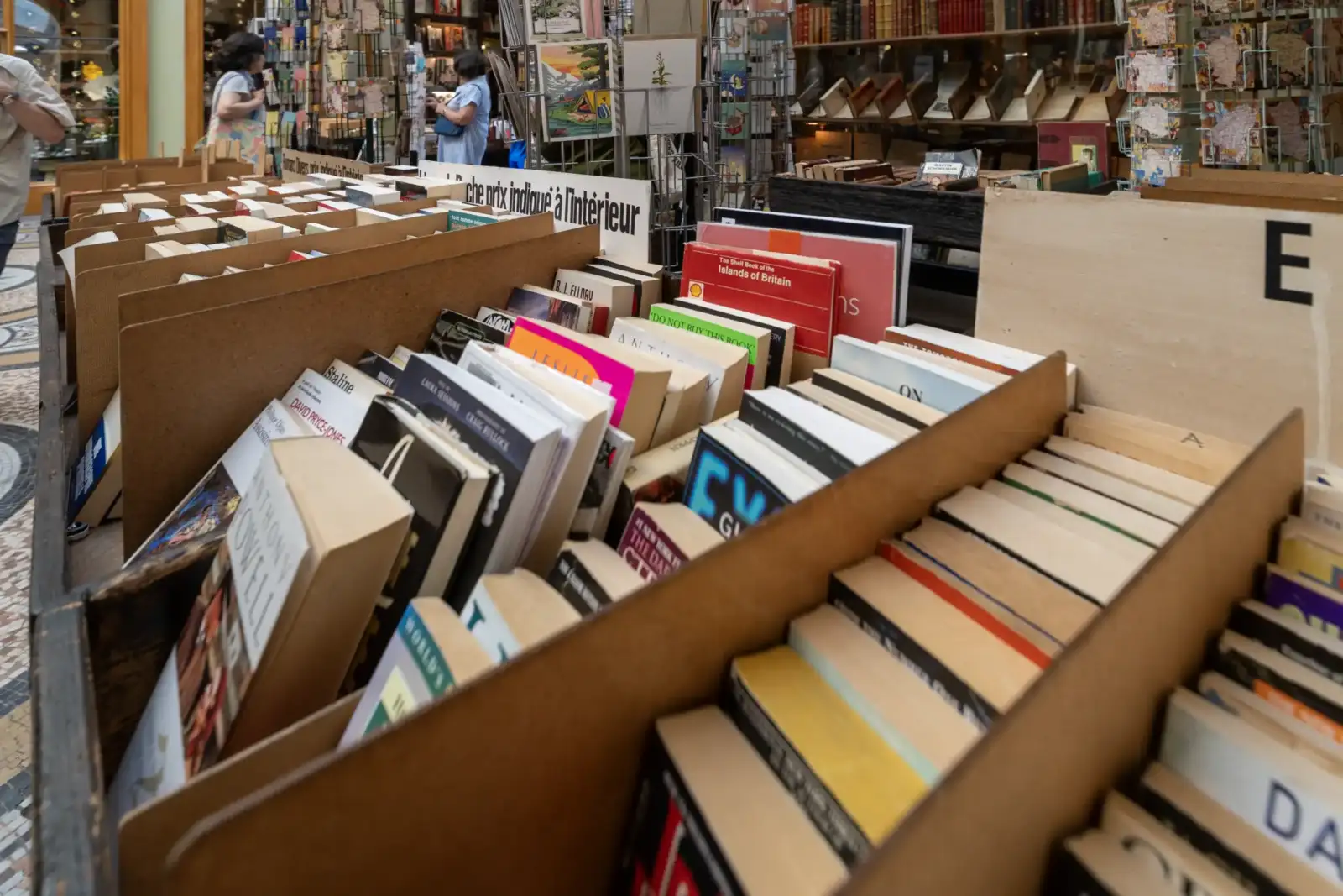 Des boîtes en bois remplies de livres d occasion alignés dans une librairie parisienne.