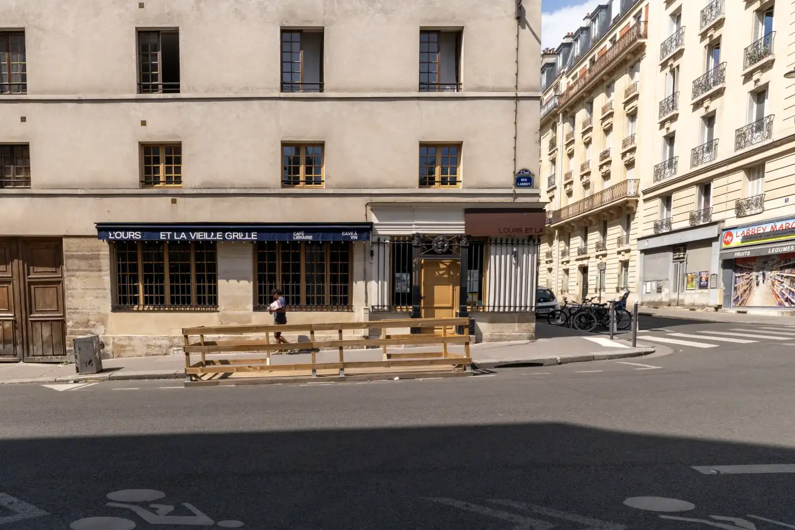 Façade ensoleillée de la librairie L Ours et la Vieille Grille à Paris.
