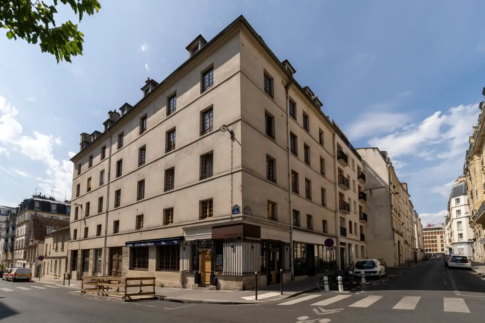 Vue d un immeuble d angle haussmannien à Paris sous un ciel bleu dégagé.