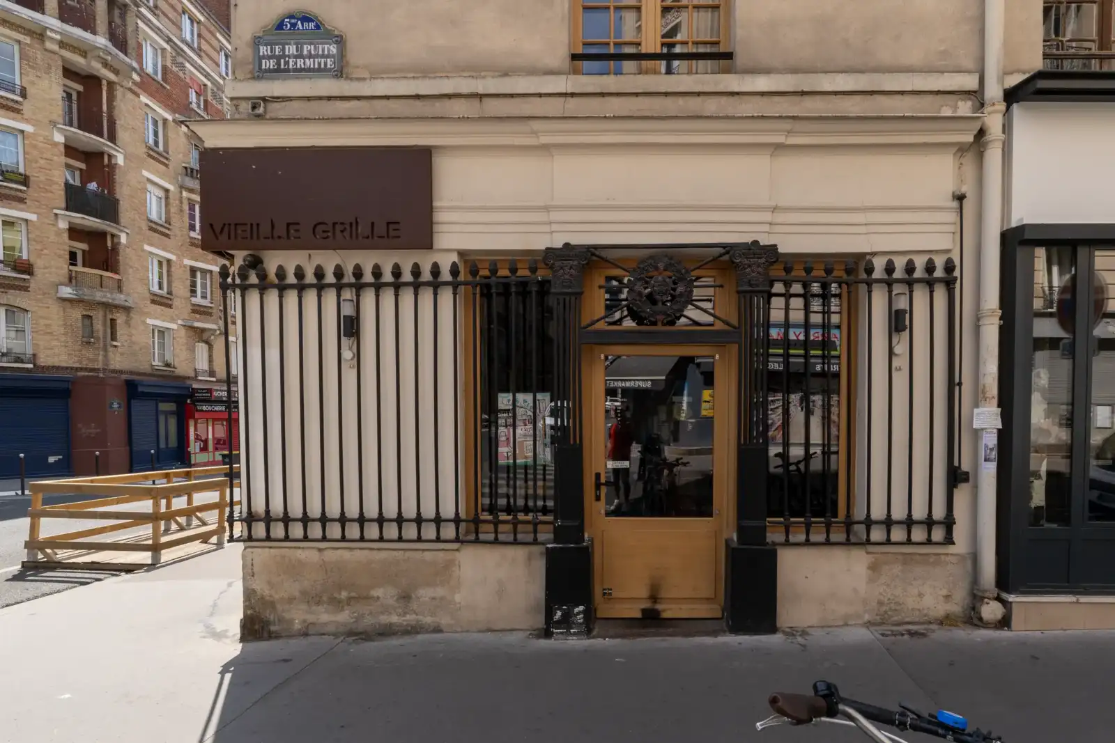 Façade de la librairie La Vieille Grille à Paris, protégée par une grande grille noire.