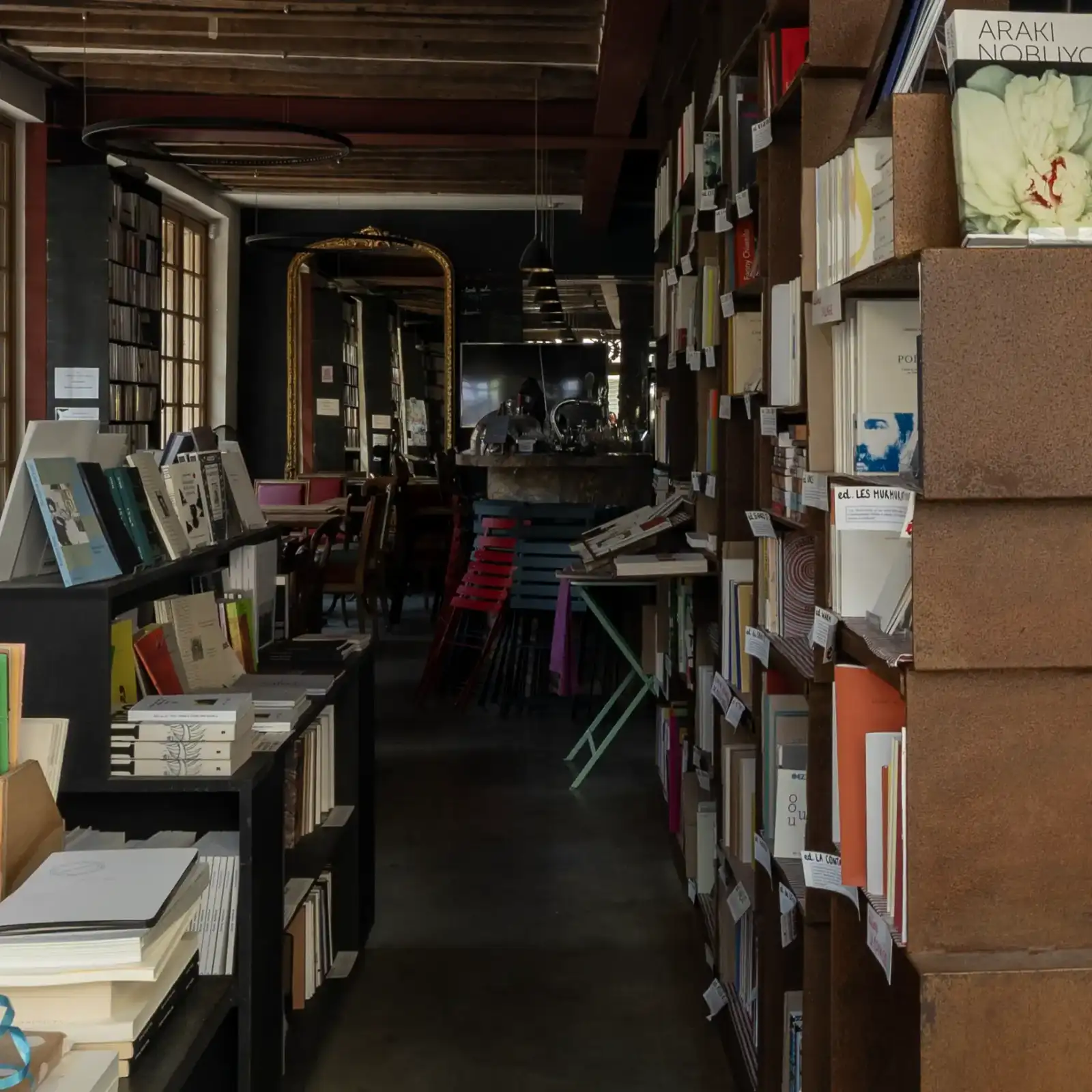 Intérieur chaleureux d une librairie parisienne avec des étagères remplies de livres et un comptoir.