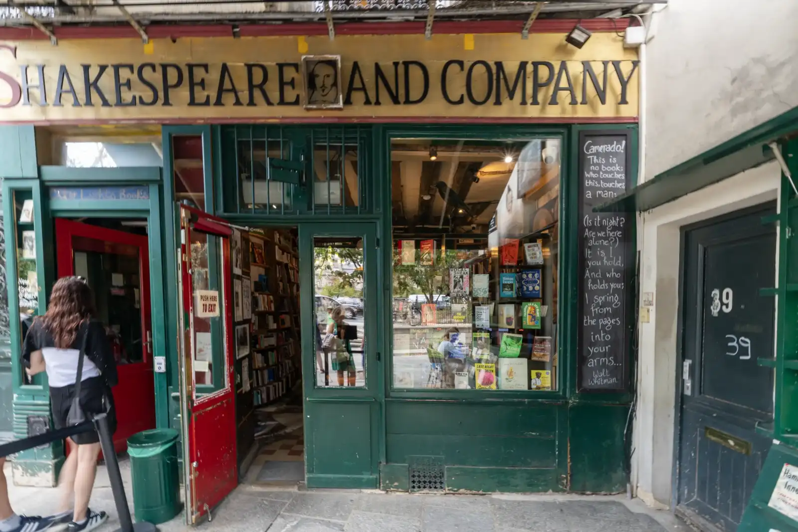 Façade colorée de la célèbre librairie Shakespeare and Company à Paris, avec vitrine et étagères.