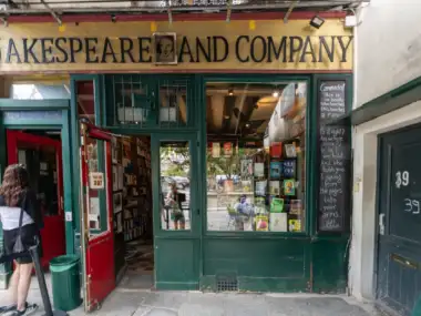 Façade colorée de la célèbre librairie Shakespeare and Company à Paris, avec vitrine et étagères.