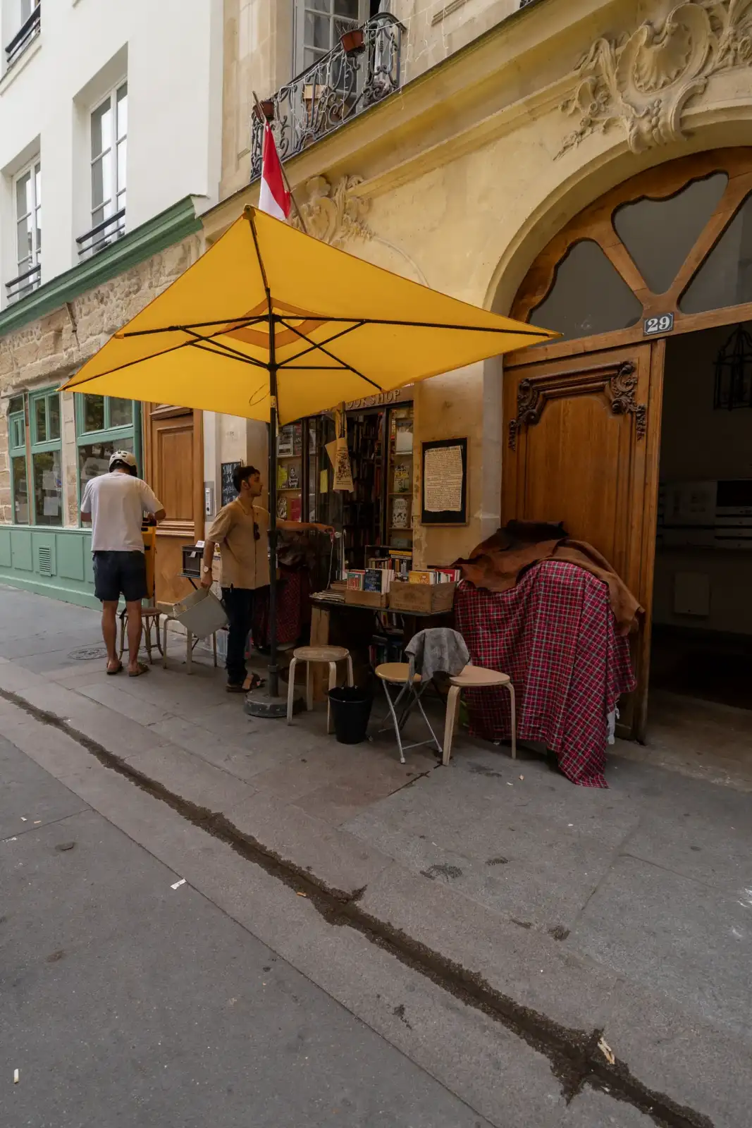 Une vue extérieure de la librairie The Abbey Bookshop avec son grand parasol jaune.