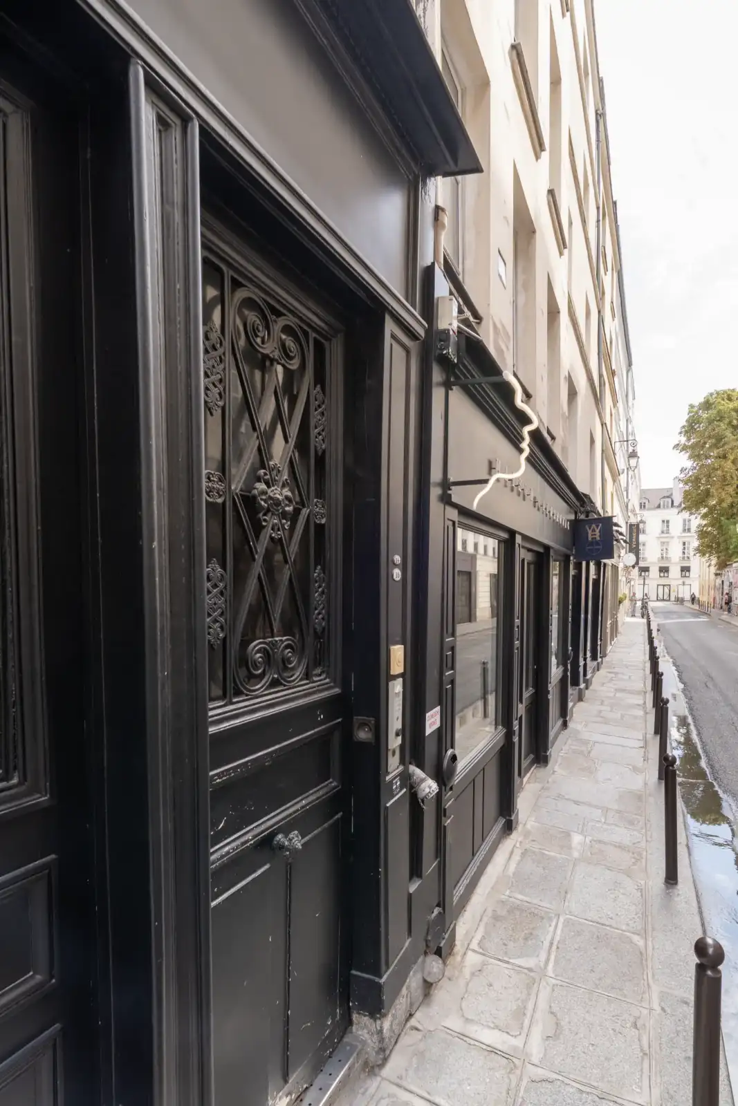 La devanture noire de la Maison Gainsbourg s'aligne le long d'une rue parisienne.