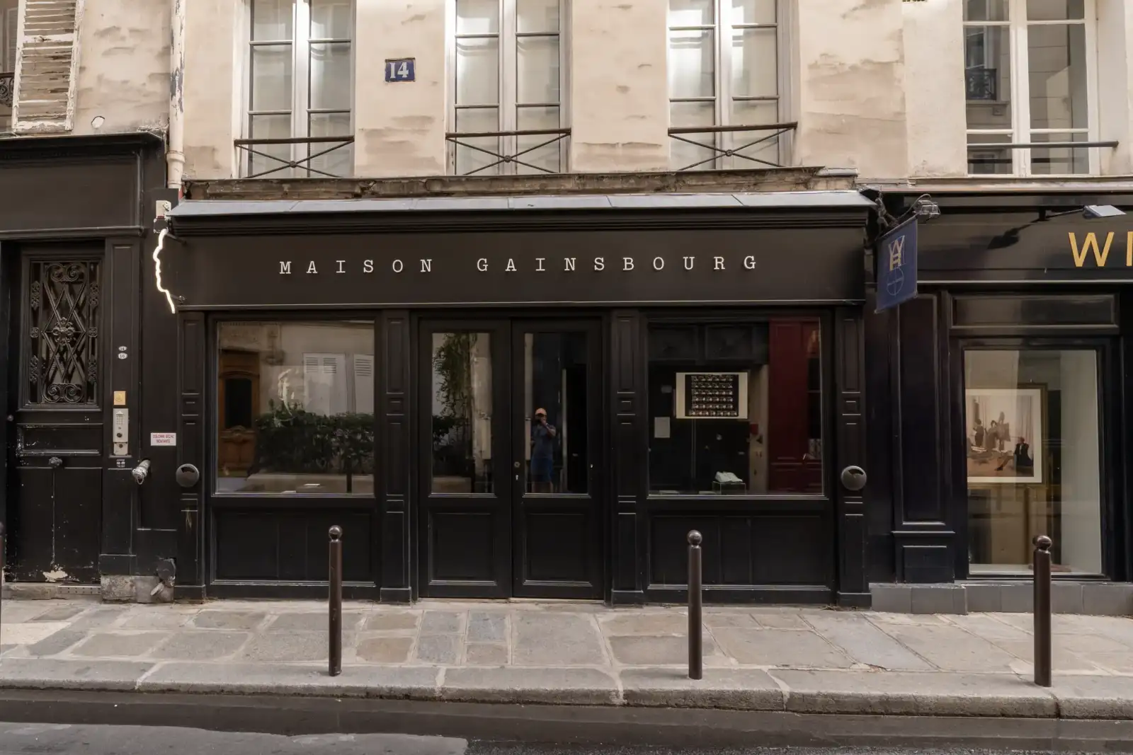 Vue de rue de la devanture noire de la Maison Gainsbourg à Paris.