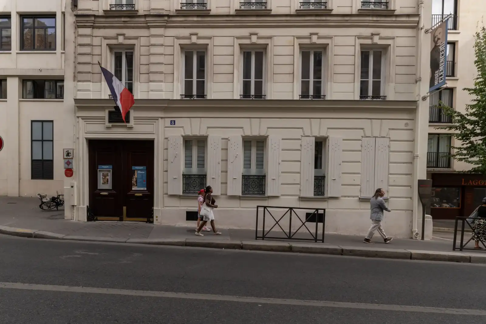 Facade de la Maison Musée Clemenceau à Paris, avec un drapeau français suspendu.