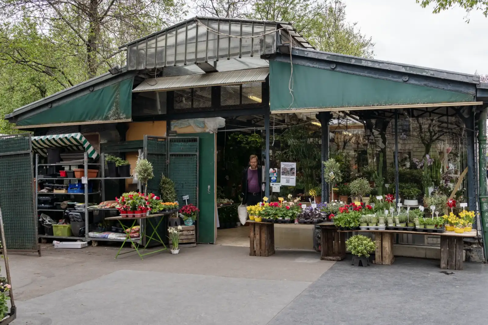 Un homme sort du marché aux fleurs Reine Elizabeth II à Paris sous verrière.