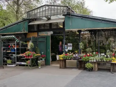 Un homme sort du marché aux fleurs Reine Elizabeth II à Paris sous verrière.