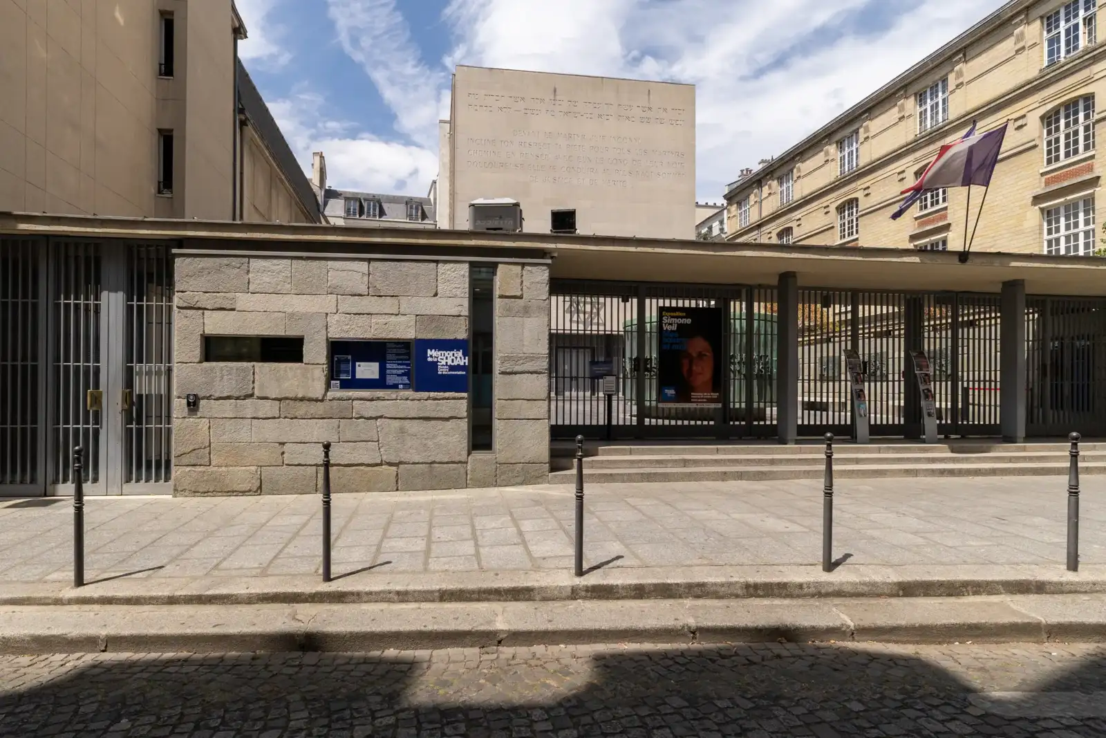 Façade en pierre du mémorial de la Shoah à Paris sous un ciel bleu.