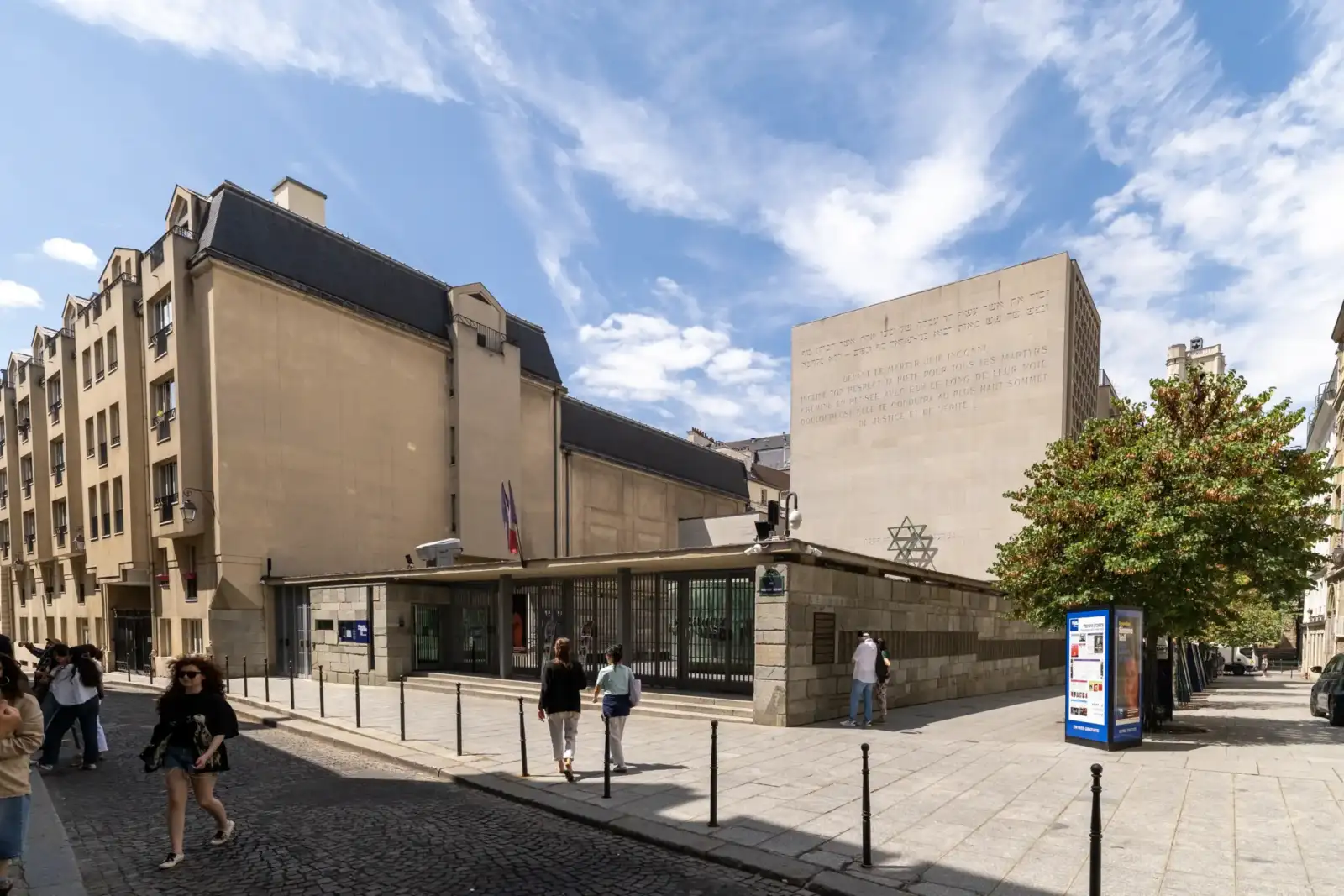 Vue extérieure du Mémorial de la Shoah à Paris sous un ciel partiellement nuageux.