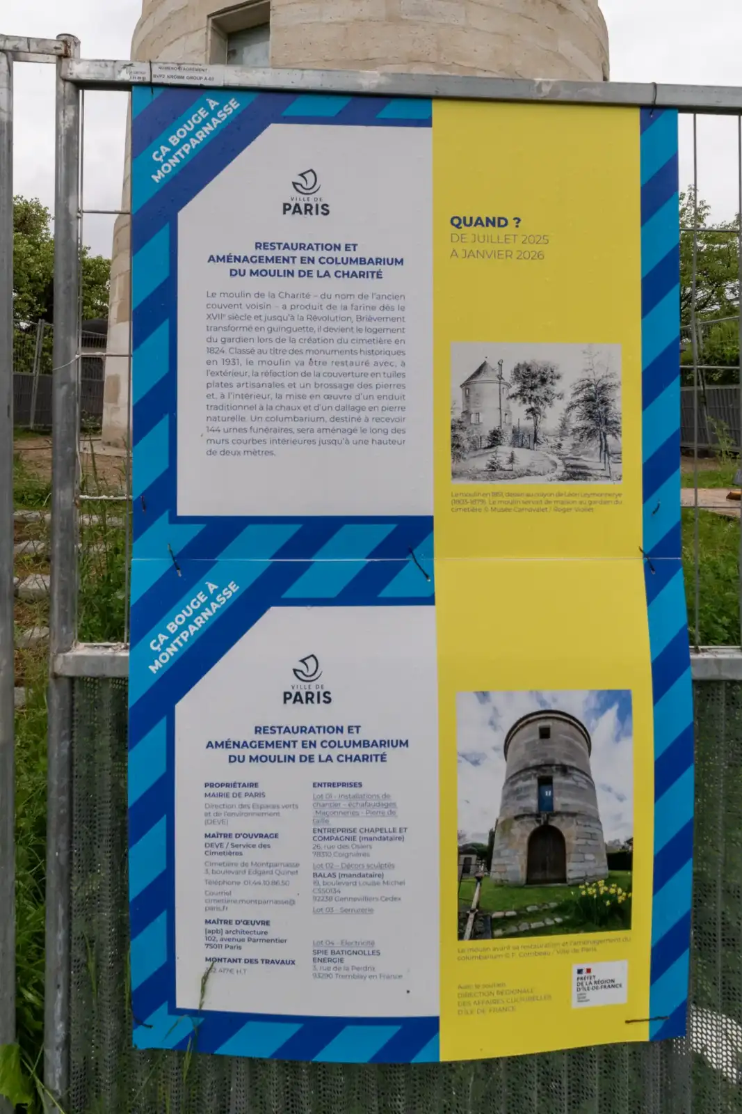 Un grand panneau explicatif fixé sur une grille métallique détaille la restauration du moulin de la Charité.
