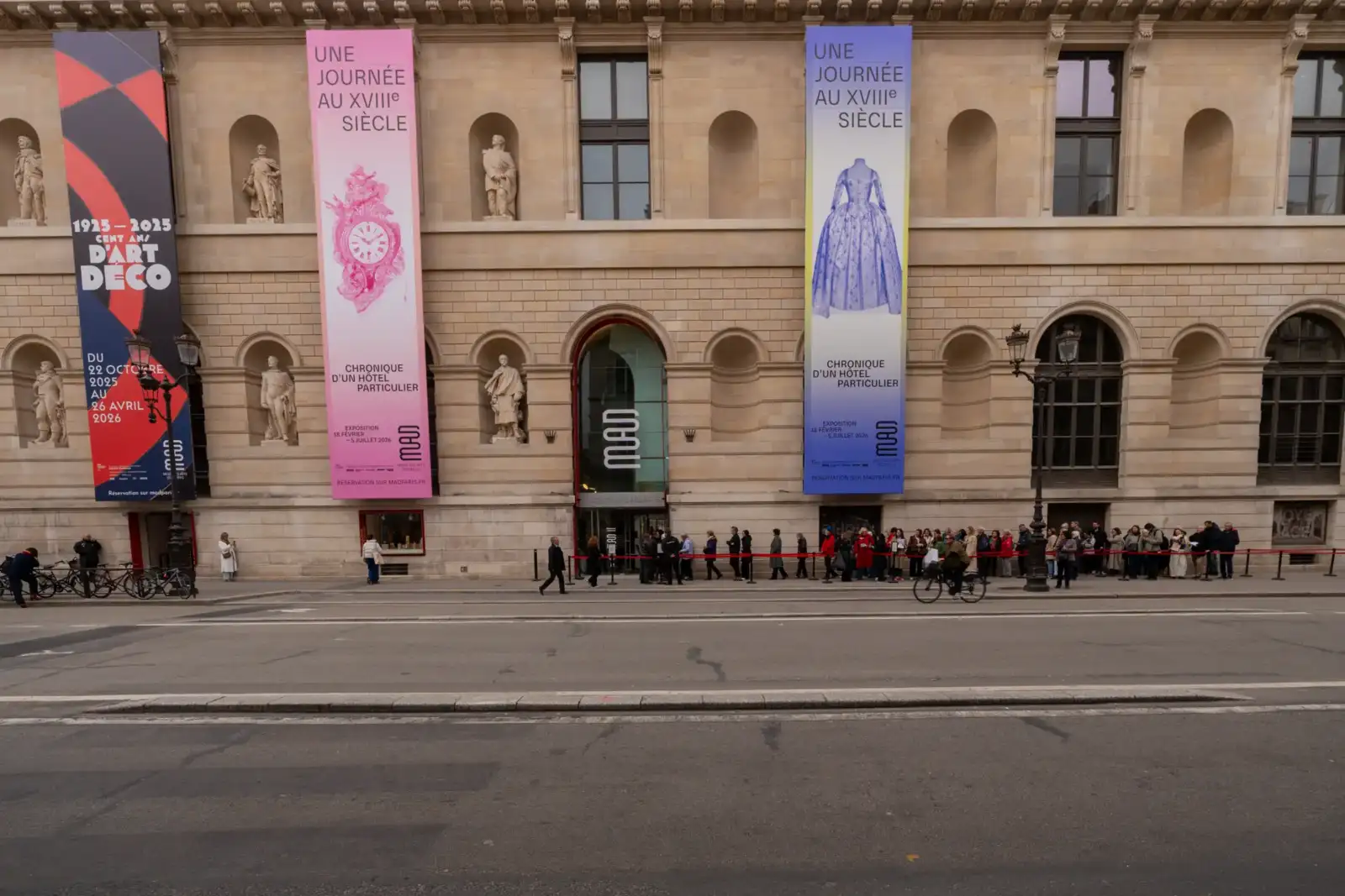 La façade du Musée des Arts Décoratifs à Paris avec des bannières d'exposition colorées.