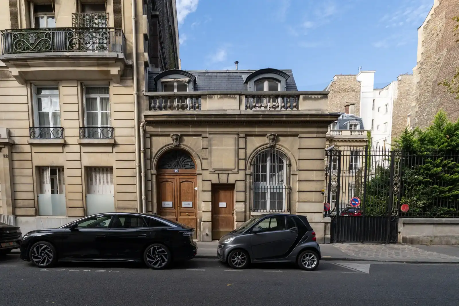 Une berline et une smart garées devant le musée de la contrefaçon à Paris.