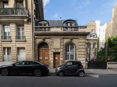 Une berline et une smart garées devant le musée de la contrefaçon à Paris.