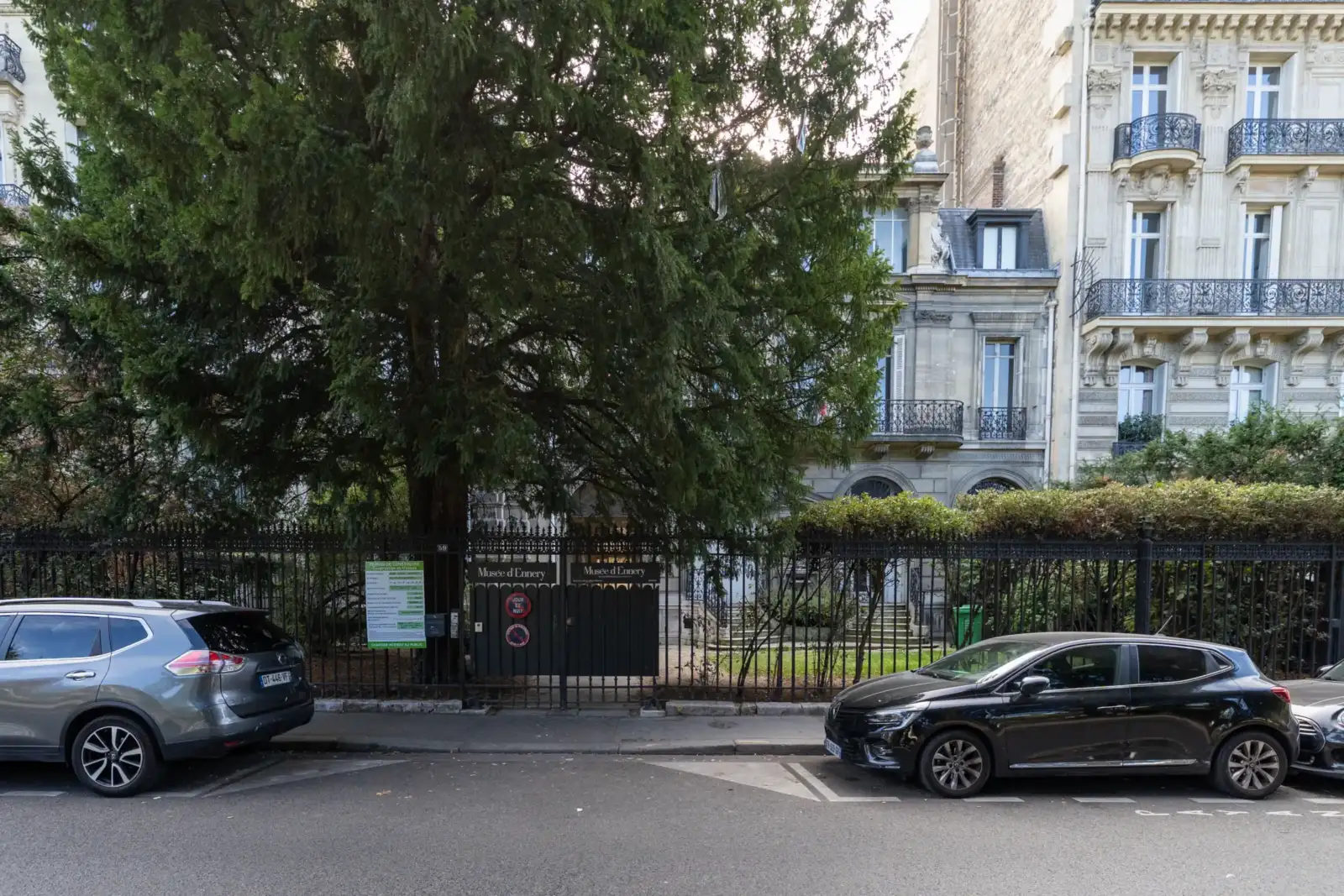 Façade classique du musée d'Ennery à Paris, en partie masquée par un grand conifère.