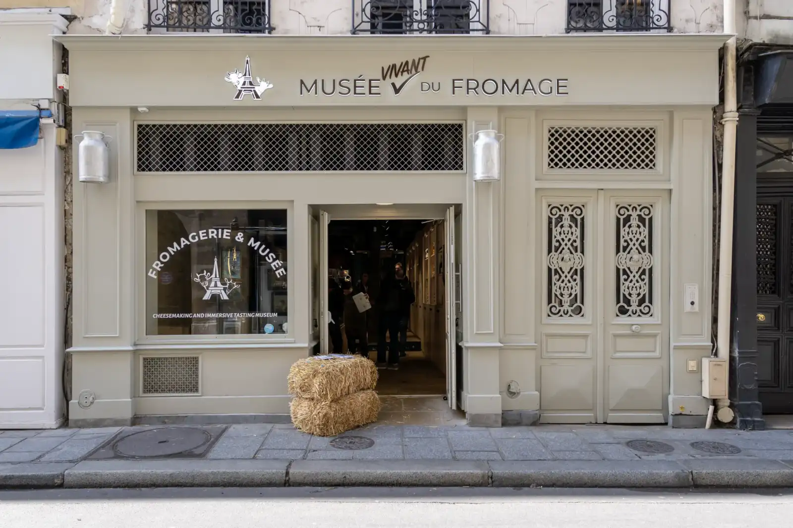 La devanture beige du Musée Vivant du Fromage avec deux bottes de paille devant.