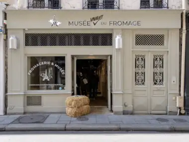 La devanture beige du Musée Vivant du Fromage avec deux bottes de paille devant.