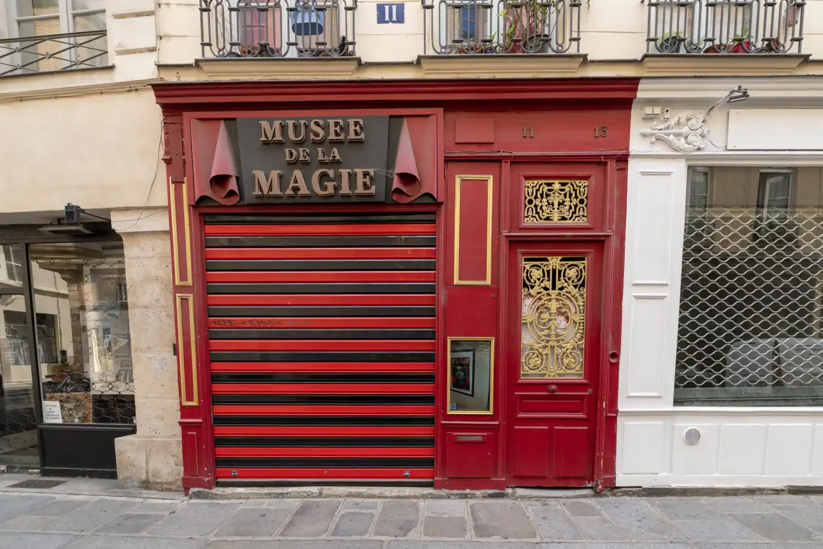 Devanture rouge et noire fermée du Musée de la Magie à Paris avec signalétique dorée.