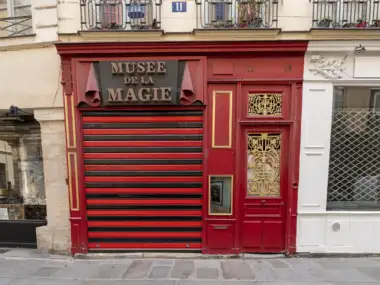 Devanture rouge et noire fermée du Musée de la Magie à Paris avec signalétique dorée.