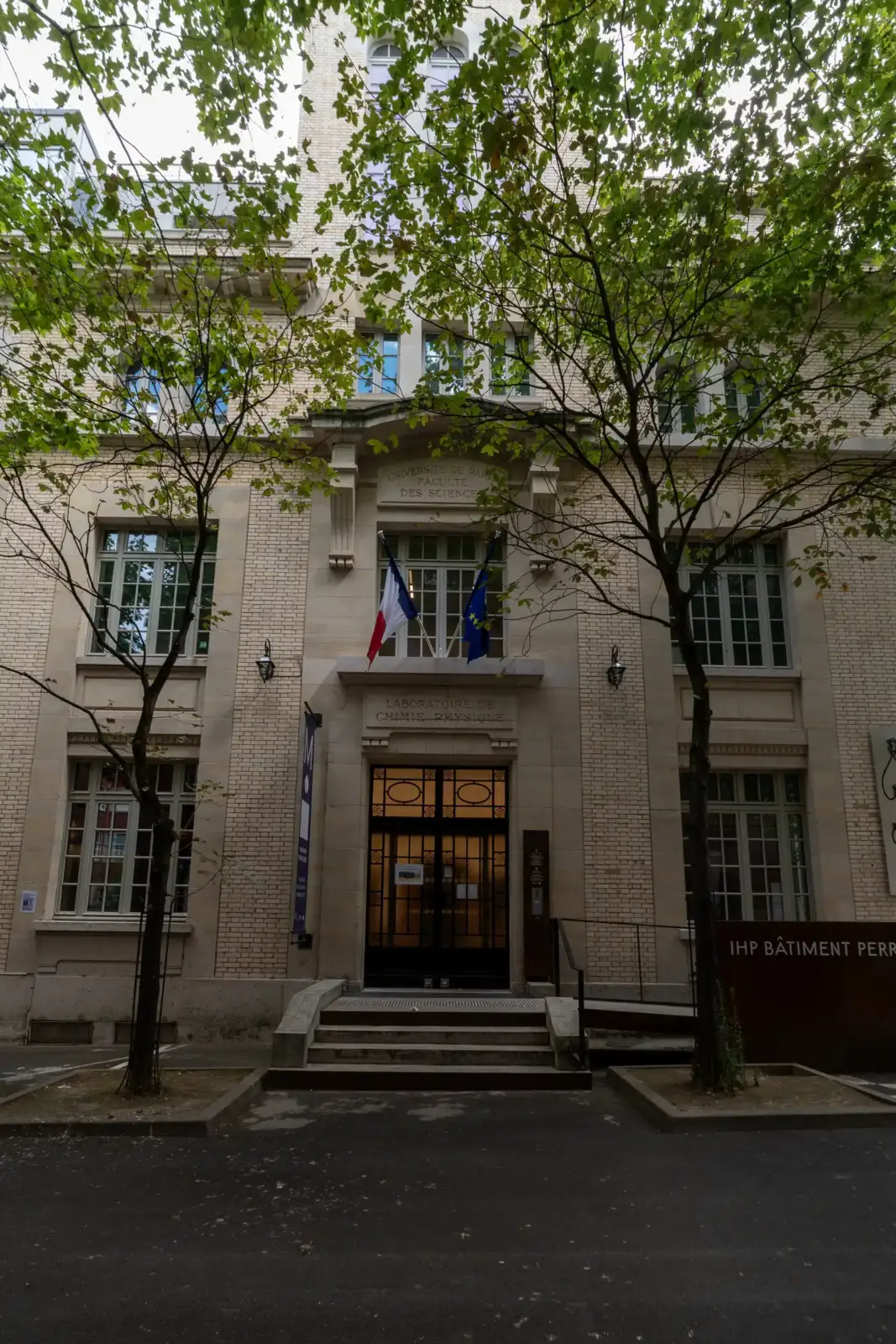 Façade claire du musée Maison Poincaré à Paris encadrée par des arbres feuillus.