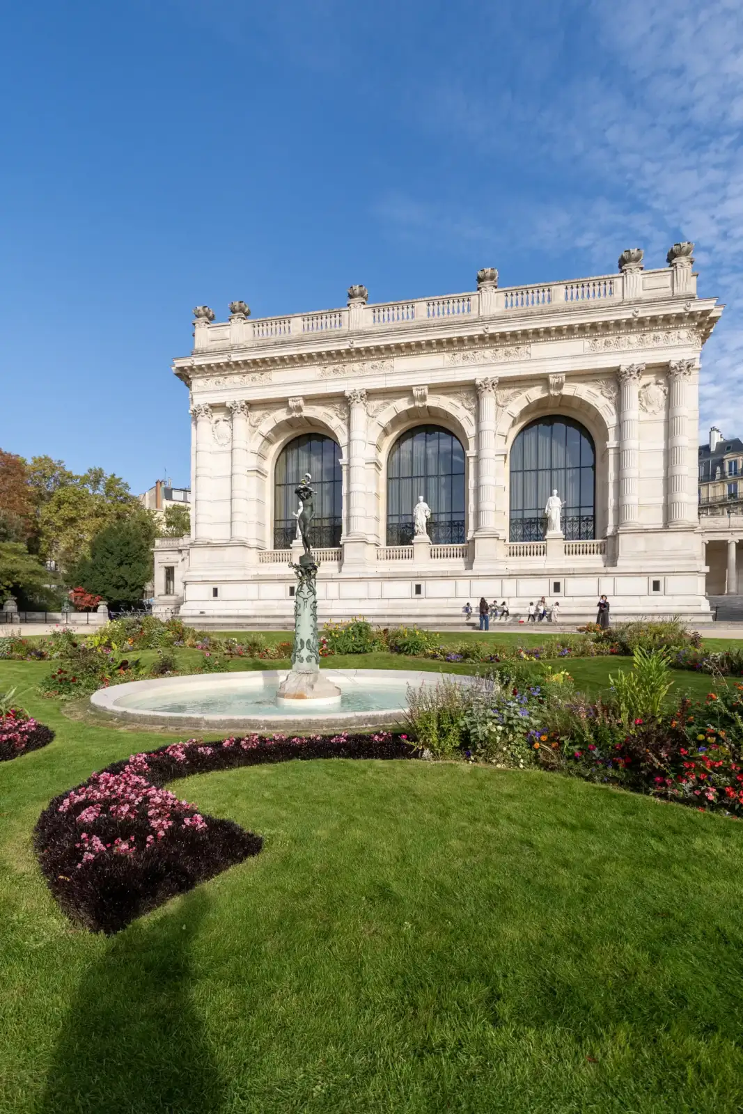 Façade élégante et jardin fleuri du palais Galliera sous un ciel bleu dégagé.