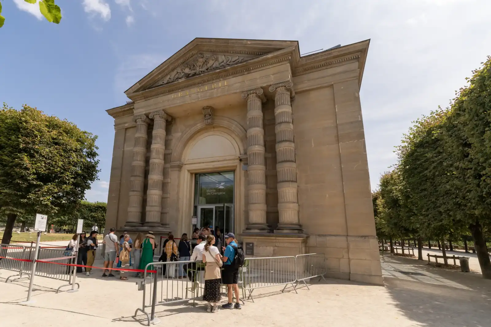 Une file de visiteurs attend devant la façade néoclassique du musée de l'Orangerie.