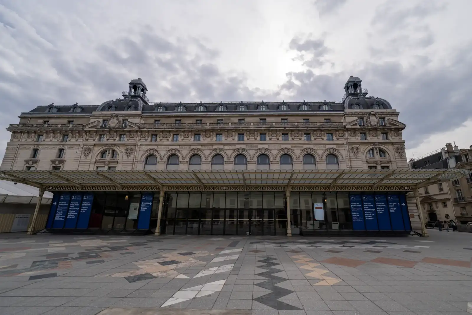 Vue large de la façade principale du musée d Orsay à Paris sous un ciel nuageux.