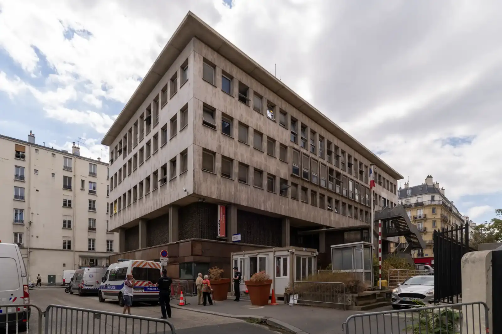 Vue extérieure du musée de la préfecture de police à Paris avec des véhicules stationnés.