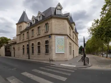 Vue de rue d'un bâtiment en pierre du Musée Rodin affichant une grande exposition.