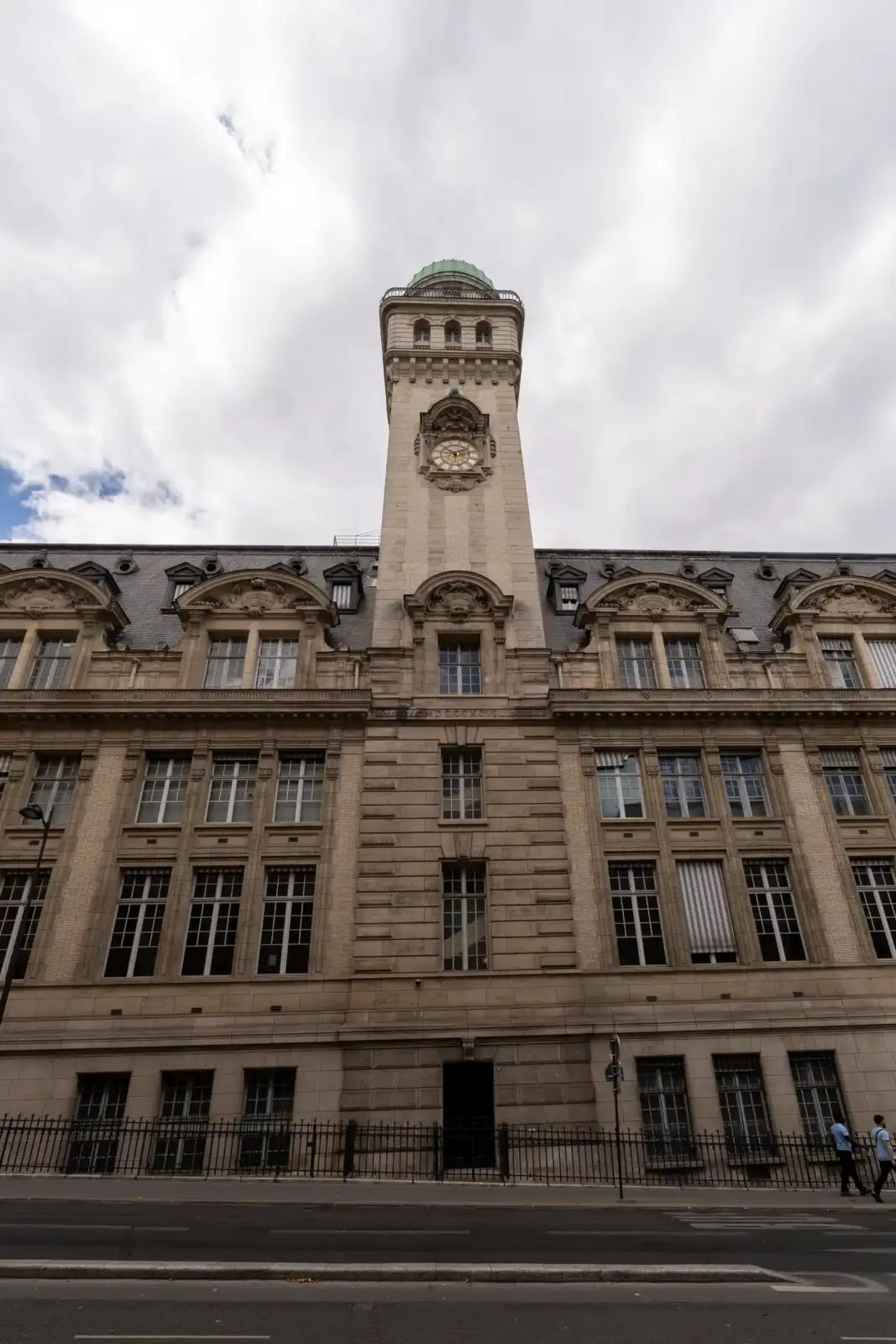 Façade en pierre de l'observatoire de la Sorbonne à Paris sous un ciel nuageux.