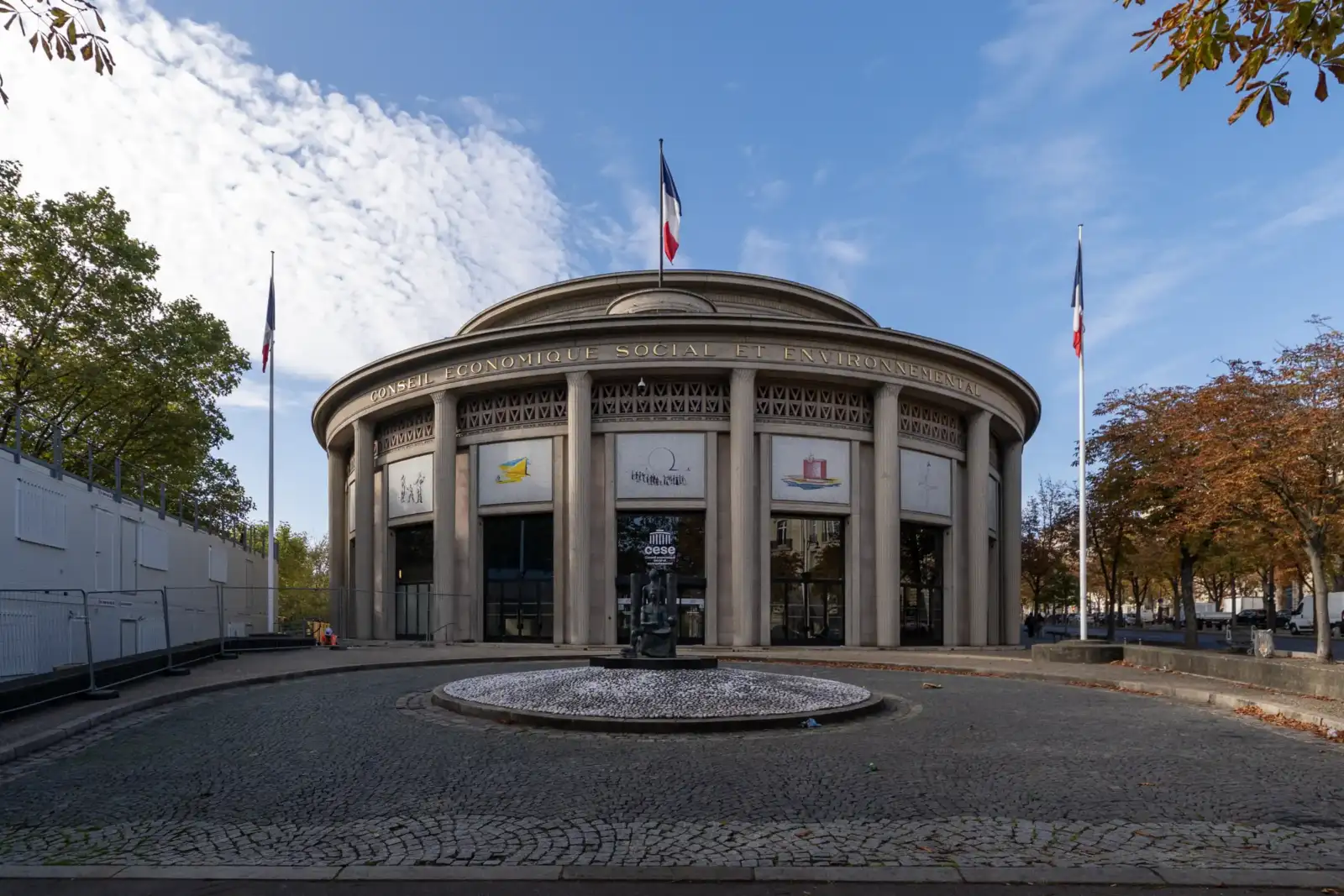 Vue extérieure de la majestueuse façade circulaire du Palais d'Iéna sous un ciel bleu.