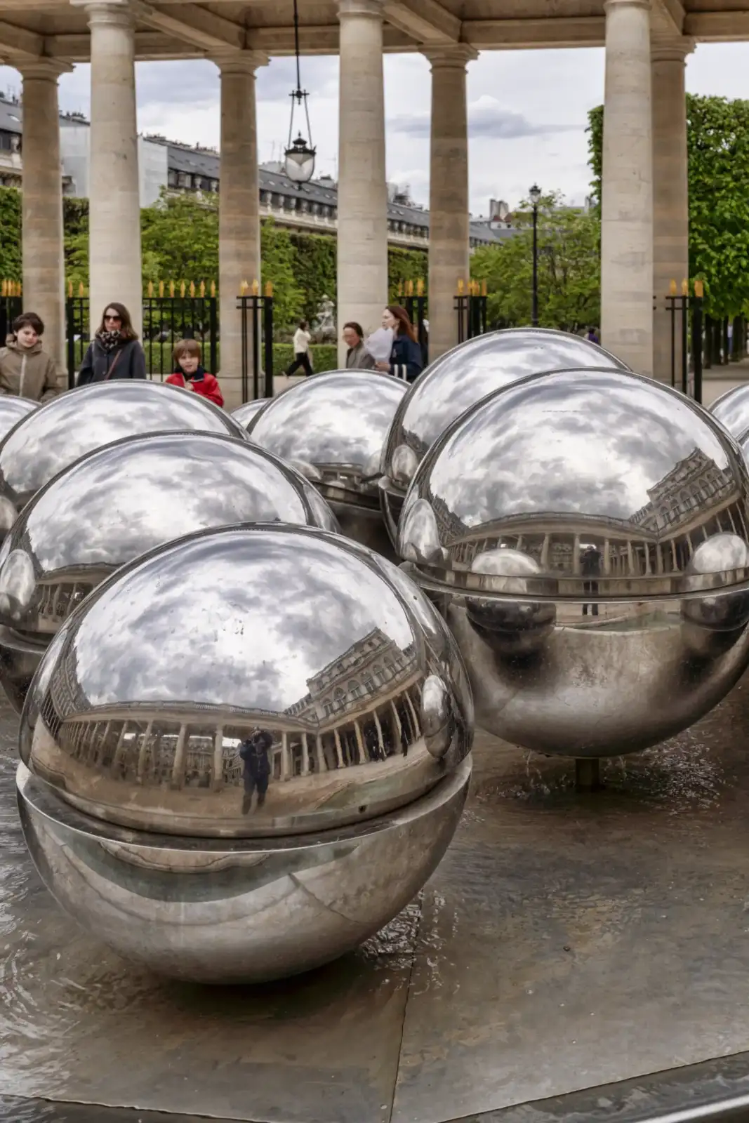 Des sphères métalliques réfléchissantes sont installées dans les jardins du Palais Royal à Paris.