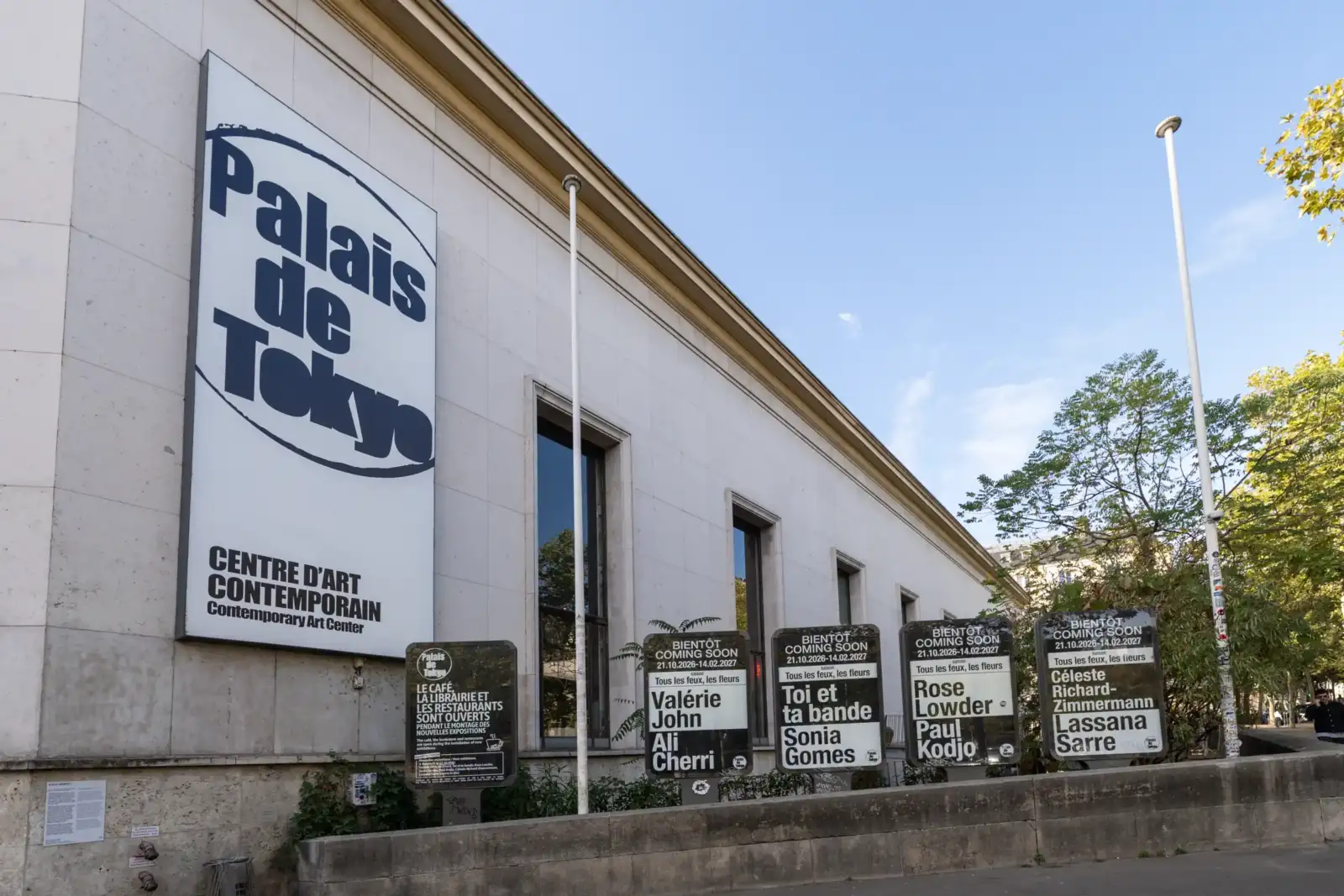 La façade blanche du Palais de Tokyo à Paris arbore une grande enseigne verticale.