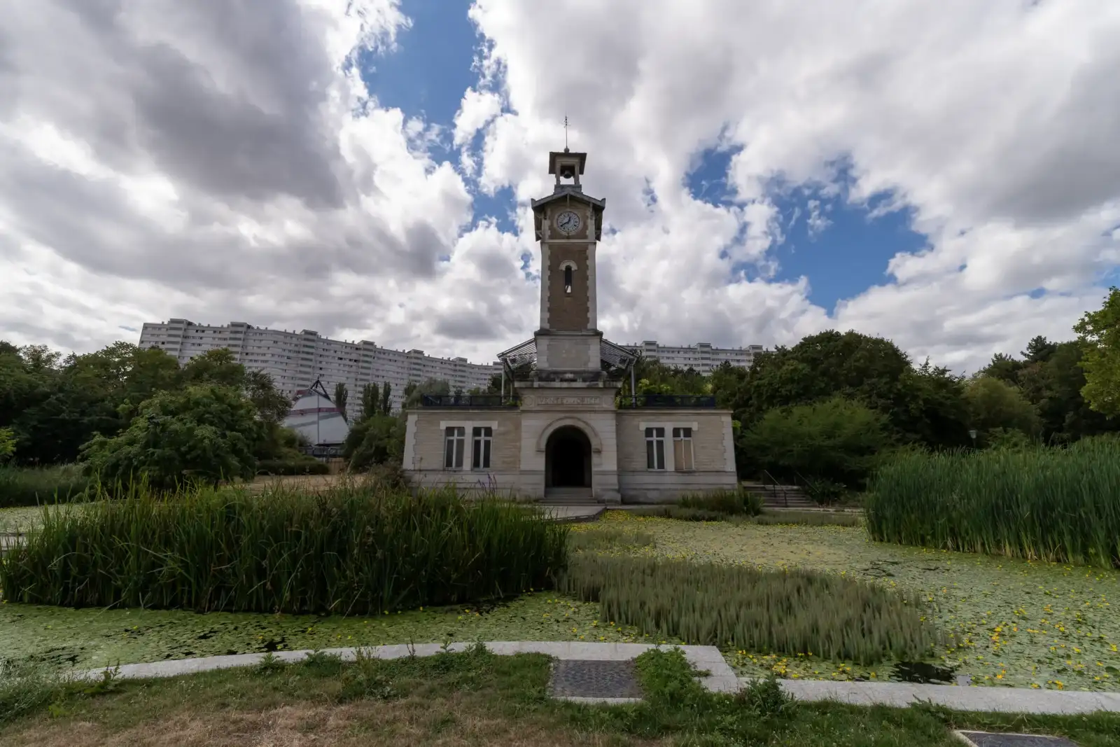 Vue de la tour horloge et de l'étang du parc Georges Brassens à Paris.