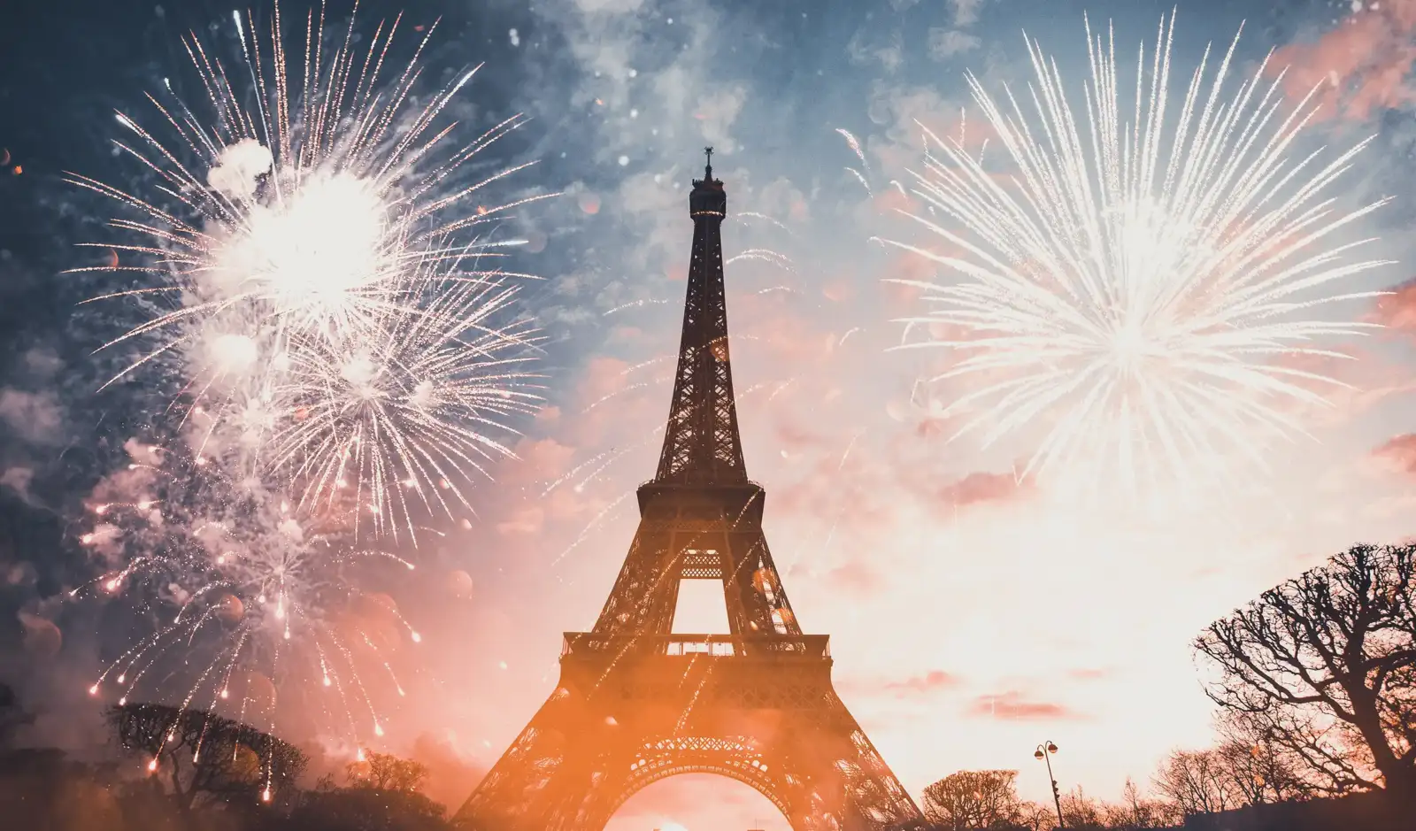 Des feux d'artifice éclatent dans le ciel de Paris illuminant la Tour Eiffel.