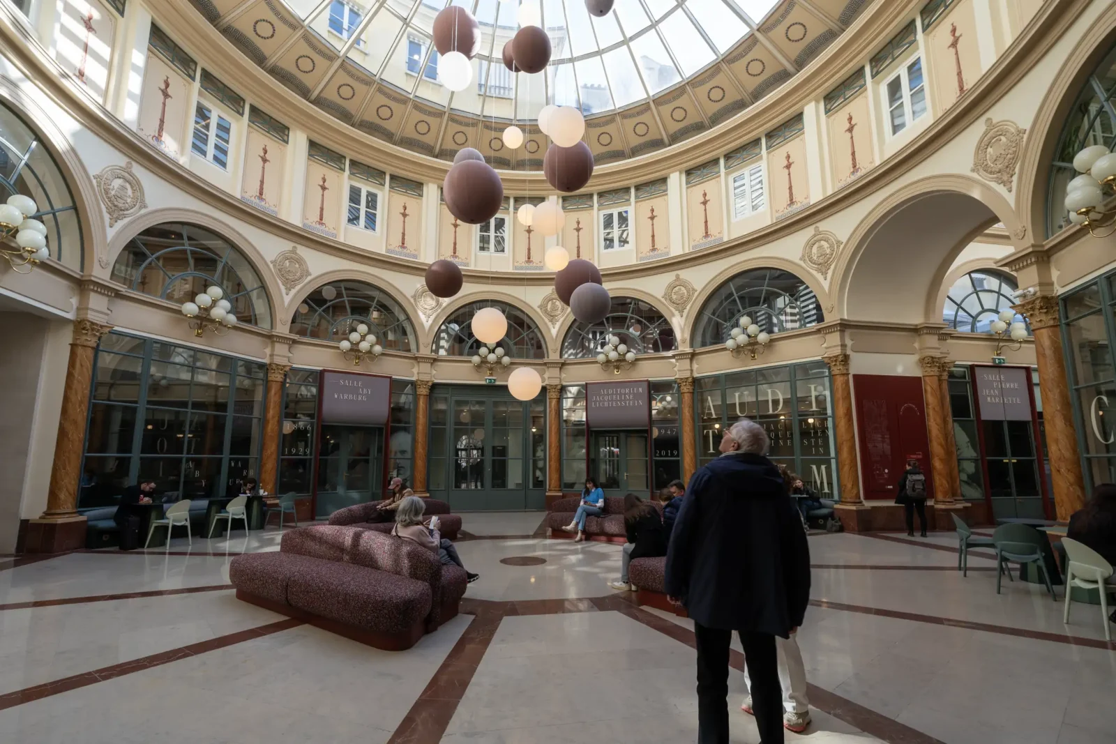Vue intérieure du Passage Colbert à Paris avec sa coupole vitrée et ses suspensions.