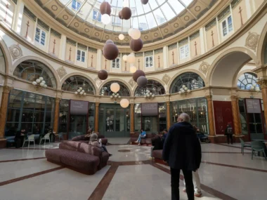 Vue intérieure du Passage Colbert à Paris avec sa coupole vitrée et ses suspensions.