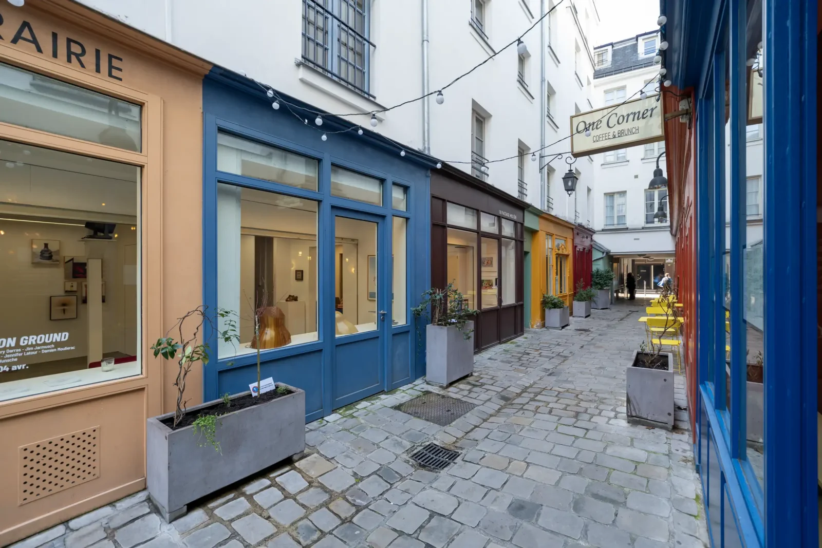 Une ruelle pavée bordée de boutiques colorées au Passage Molière dans le troisième arrondissement.