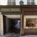 L'entrée pavée du Passage Molière à Paris avec une boutique de papier artisanal adjacente.