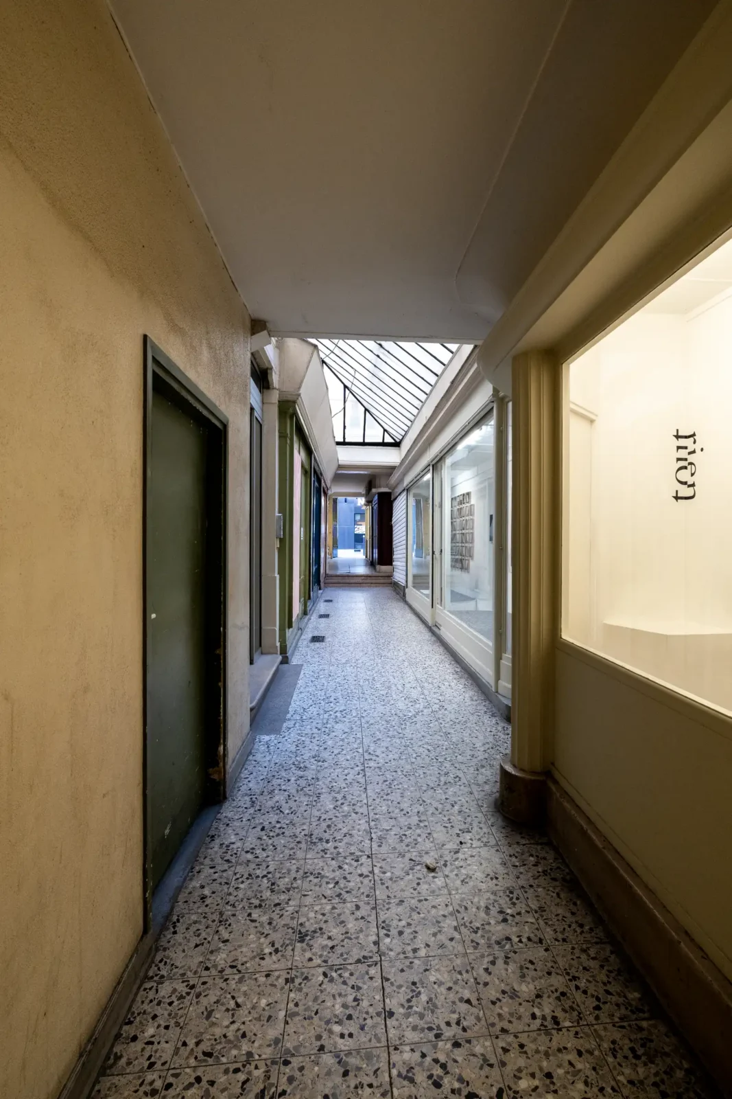 Une allée étroite et couverte du Passage Sainte-Anne avec un sol en terrazzo clair.