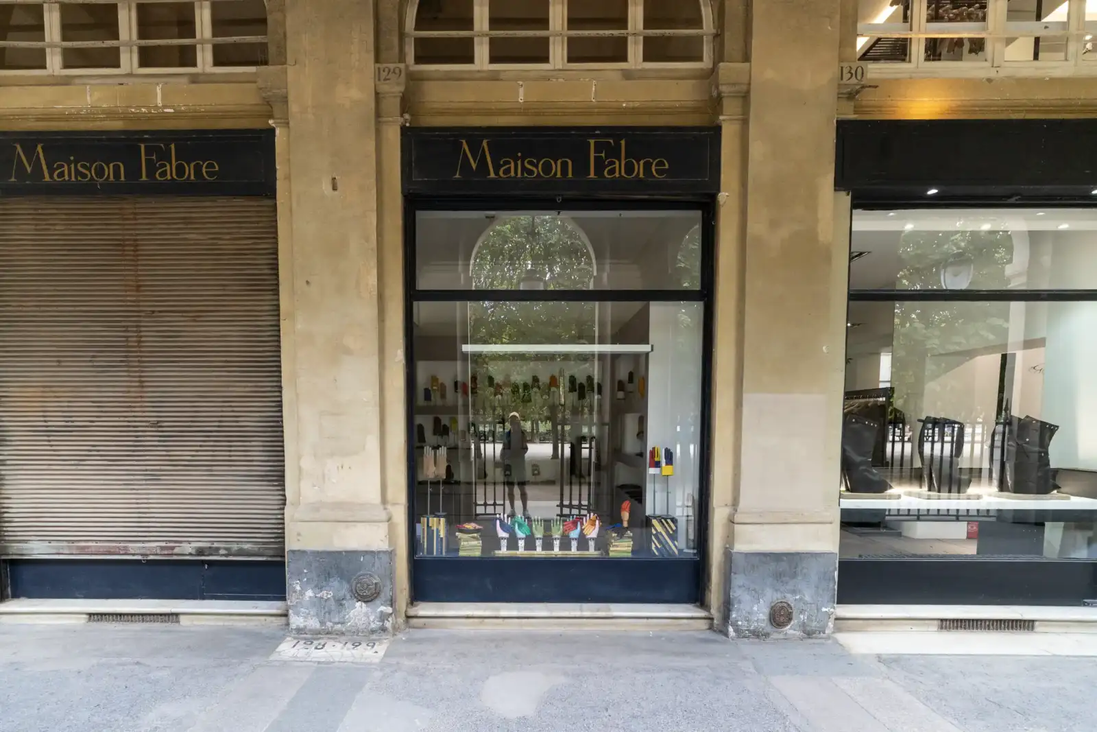 Vitrine de la Maison Fabre, un magasin de gants élégant sous des arcades parisiennes.