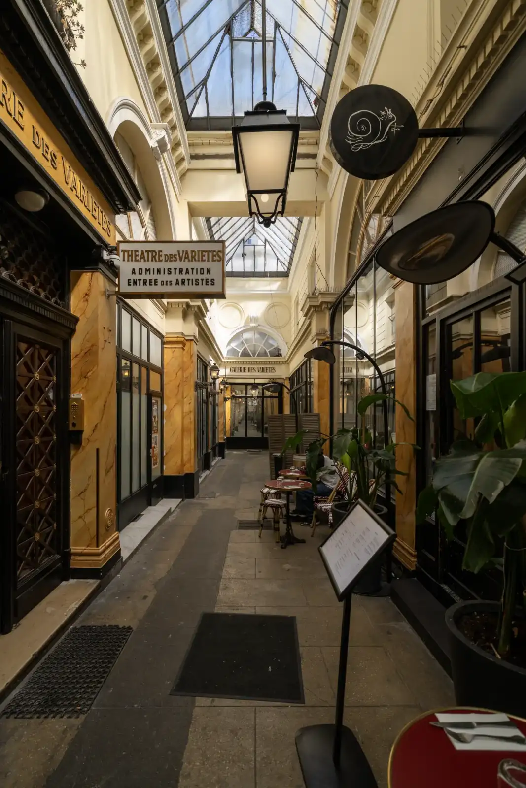 Vue plongeante sur le Passage des Panoramas avec ses enseignes anciennes et son verrière lumineuse.