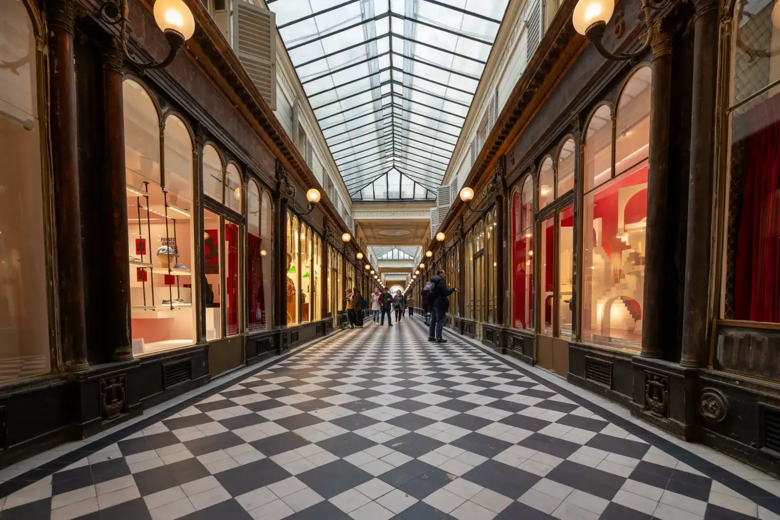 Le Passage Véro-Dodat à Paris présente une galerie couverte au sol en damier noir.