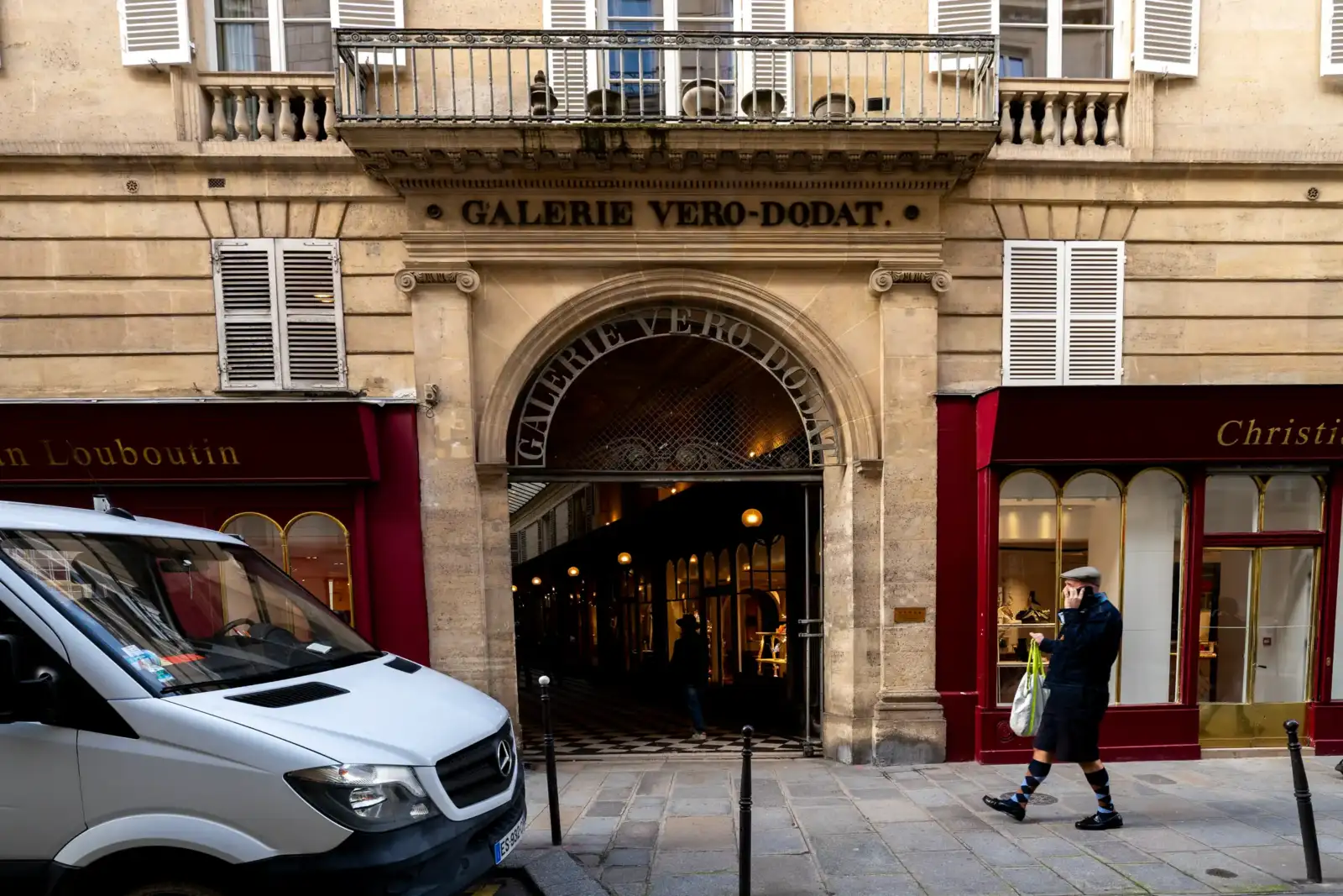 Un homme téléphone devant la façade historique de la Galerie Véro-Dodat à Paris.
