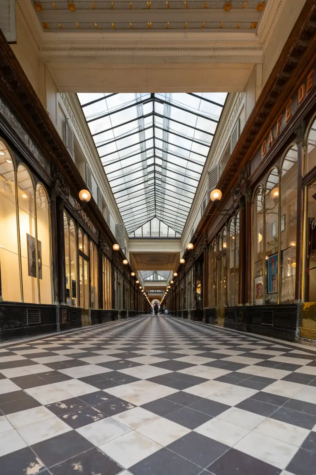 Vue perspective du Passage Véro-Dodat à Paris avec son sol en damier noir blanc.