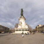 La statue monumentale de la place de la République à Paris sous un ciel nuageux.