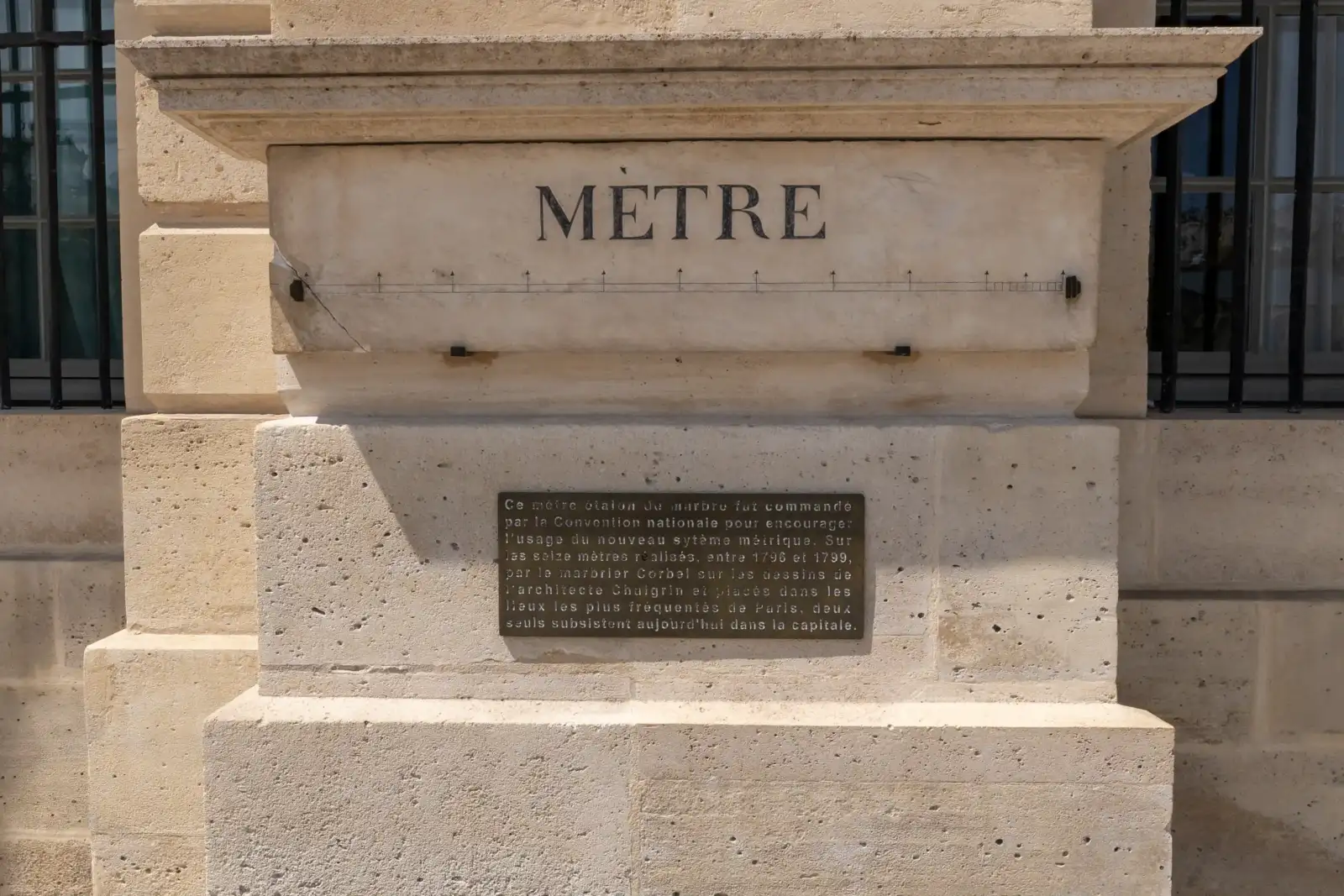 Une plaque en marbre gravée indiquant le mètre étalon sur un mur parisien.