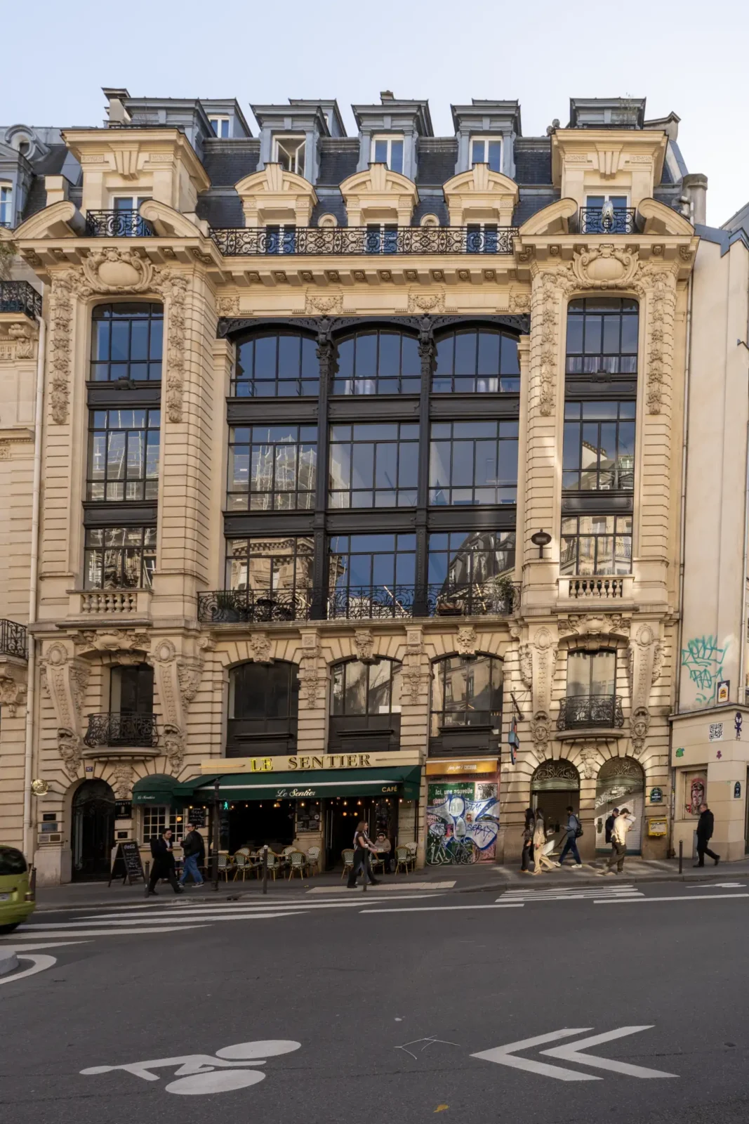 Façade haussmannienne ornée d'un café au rez-de-chaussée dans le quartier parisien du Sentier.